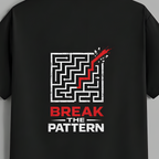 A black short-sleeve t-shirt hanging on a wooden hanger against a solid gray background. The back of the shirt features a graphic print with a white maze, a red checkmark, and the text 'BREAK THE PATTERN' in red and white.