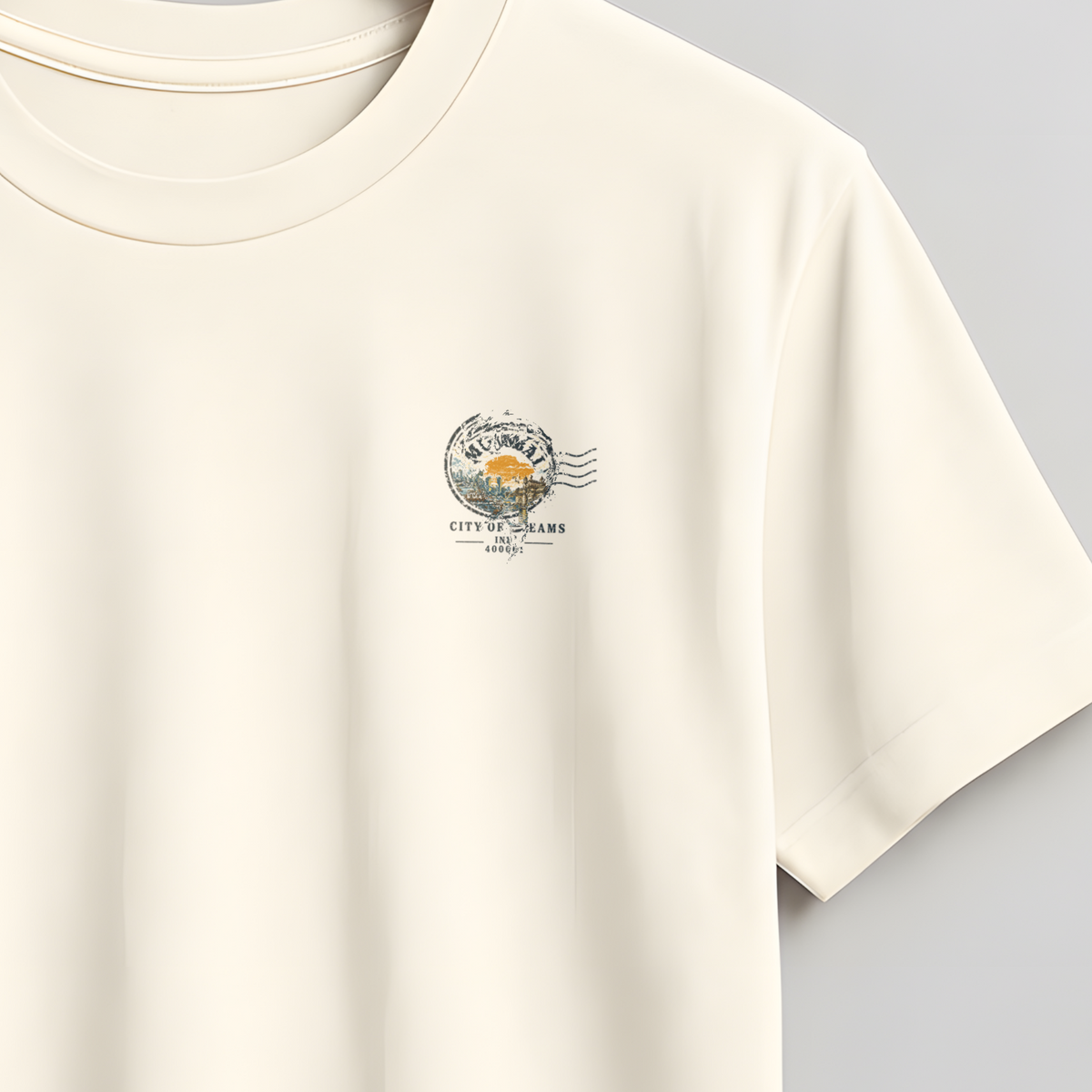 An off-white short-sleeve crewneck t-shirt hanging on a wooden hanger against a neutral gray background. The shirt features a small, delicate pink and orange graphic on the left chest.