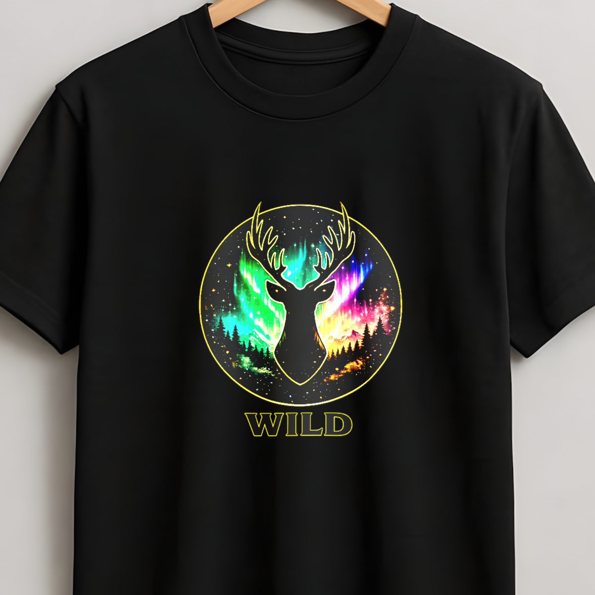 A black short-sleeve crewneck t-shirt hanging on a wooden hanger against a light gray wall. The shirt features a circular graphic on the chest with a deer head silhouette filled with a vibrant, multicolored neon-like pattern, and the word 'WILD' printed below in a gold font.