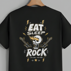 A black short-sleeve t-shirt hanging on a wooden hanger against a solid gray background, featuring a large graphic print on the back with the words 'EAT SLEEP ROCK' and a skull playing a guitar.