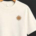 An off-white short-sleeve crewneck t-shirt hanging on a wooden hanger from a black clothing rack, featuring a small embroidered sun design on the left chest.